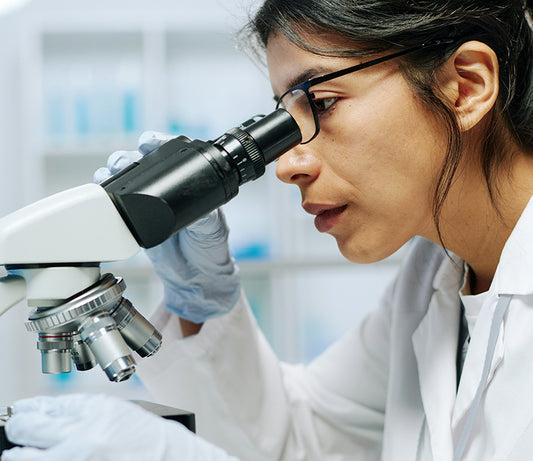 scientist looking through a microscope